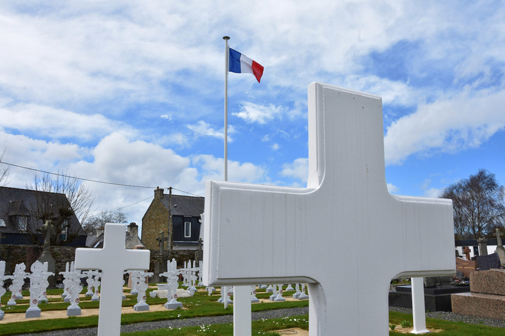 89 croix blanches sont parfaitement alignées dans un carré d'herbe. Au milieu, le drapeau français flotte à  quelques mètres du sol.